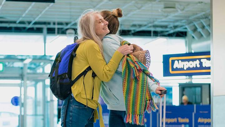 Two women embrace at an airport