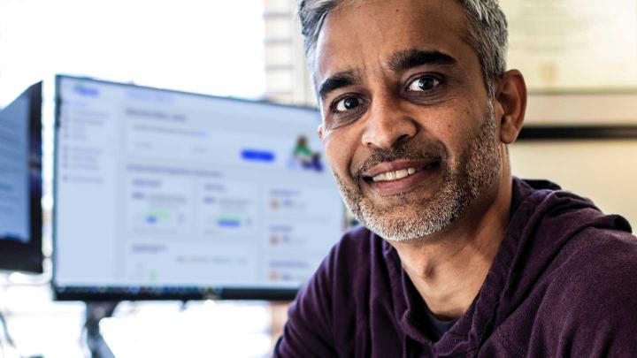 A man sits in front of a desktop computer