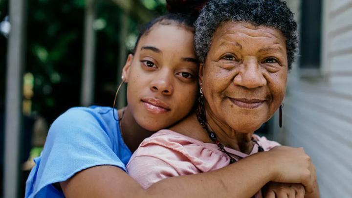 a young person hugs an older family member