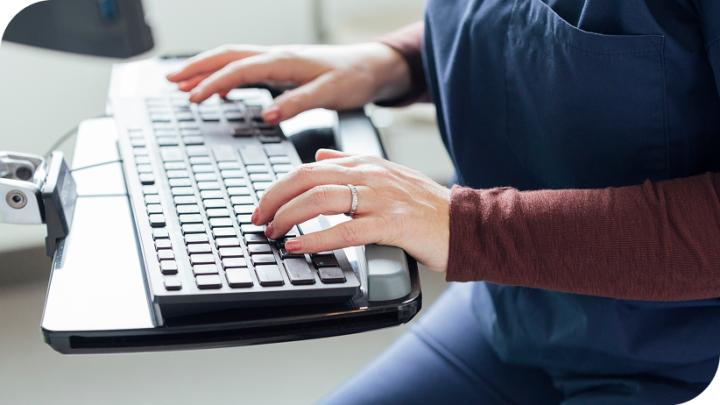 hands type on a computer keyboard