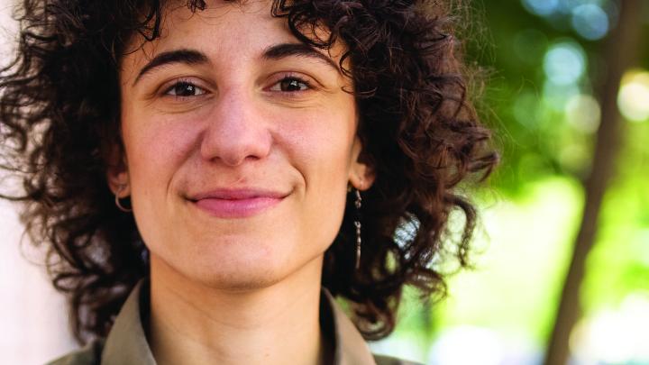 Smiling woman with curly hair outdoors in natural light
