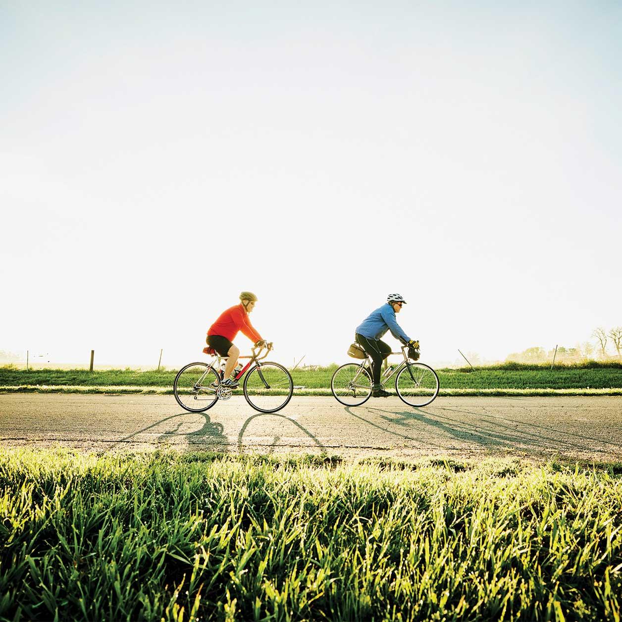 Two people ride bikes