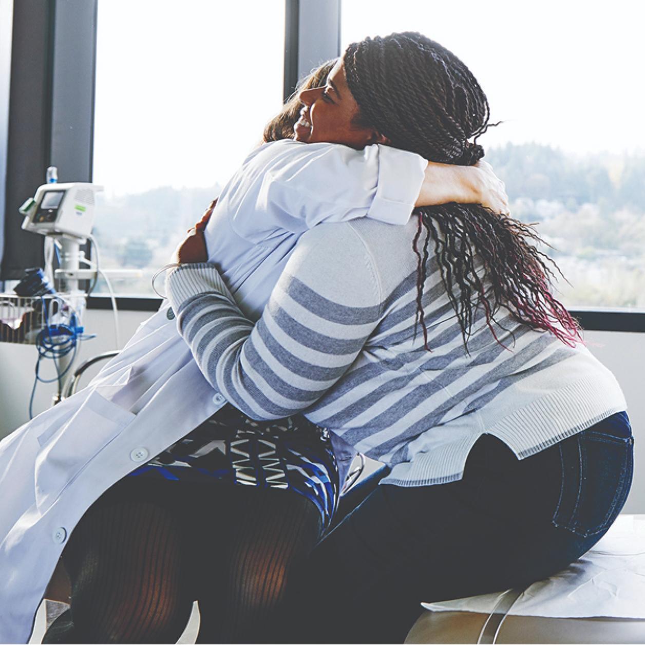 A healthcare worker hugs a patient