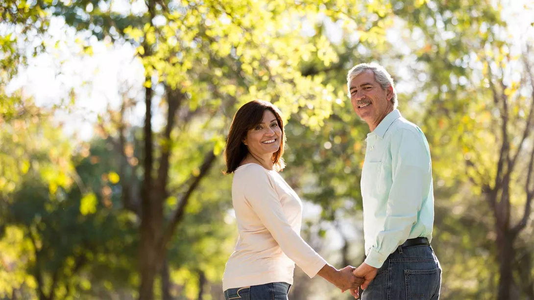 A man and woman walk hand in hand