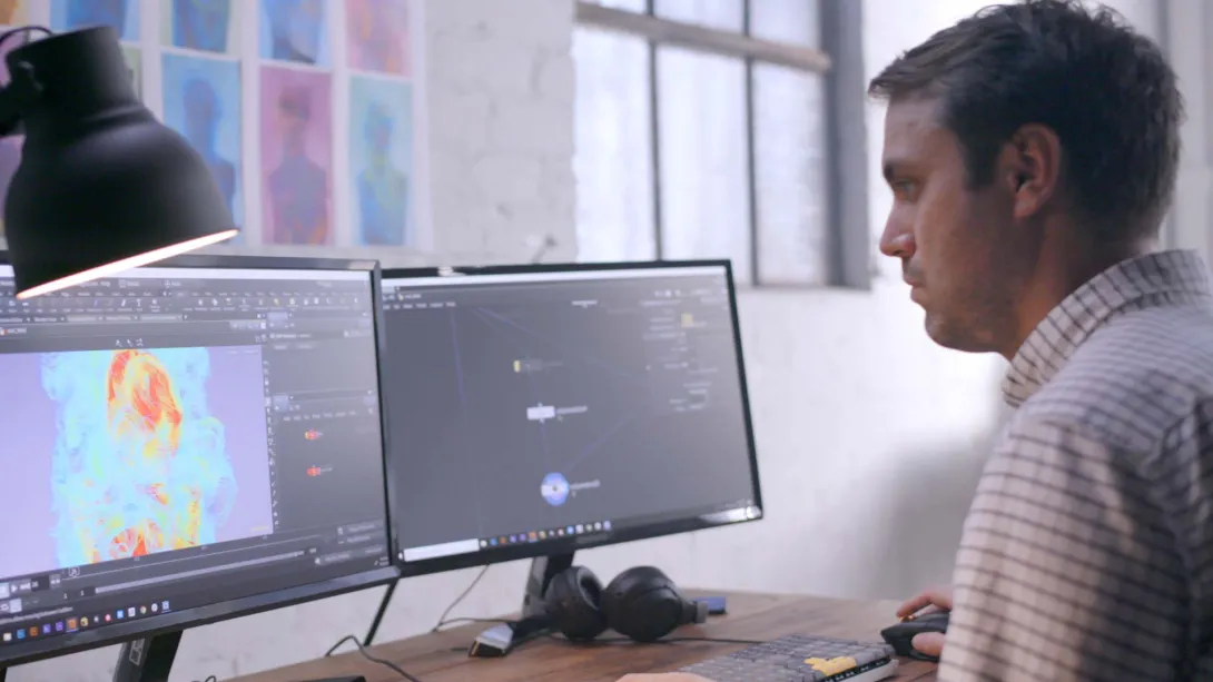 Person sits in front of two computer monitors