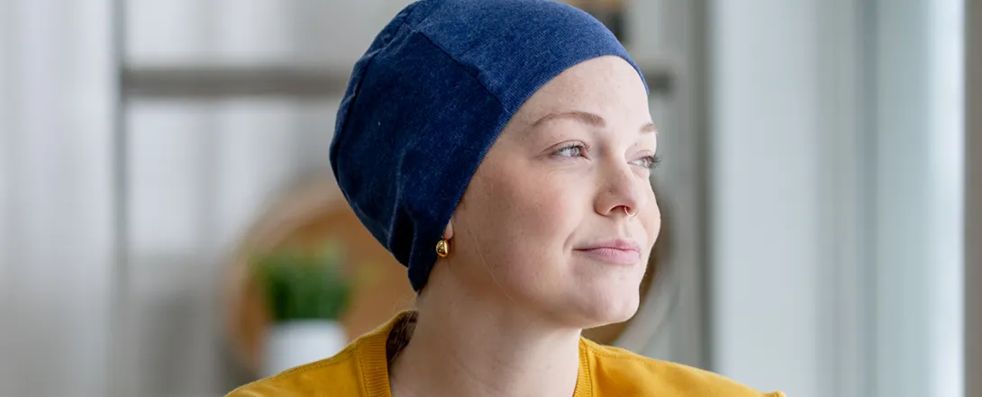A woman wearing a head covering looks to the side