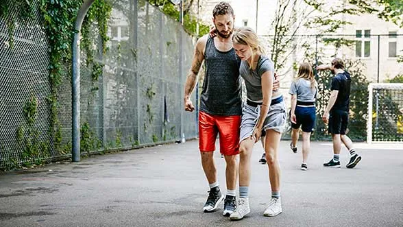 A person helps an injured friend walk