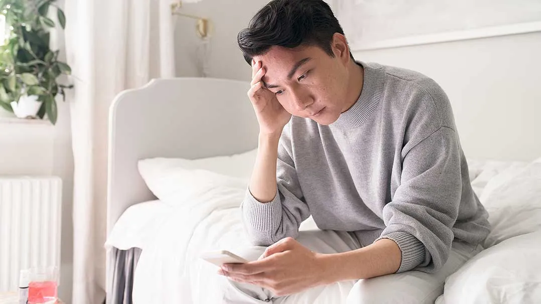 A person looks upset or stressed while viewing their phone