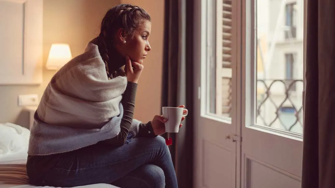 A woman looks out a window