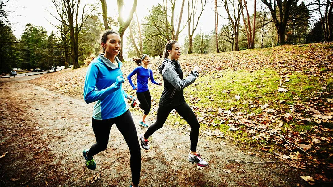 a group of three runs in a park