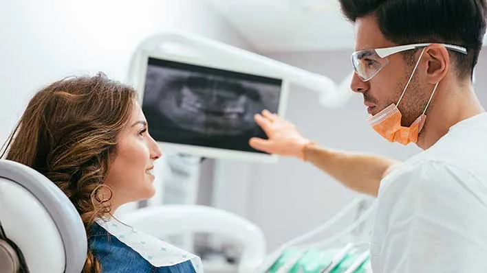 A technician reviews x-rays with a patient